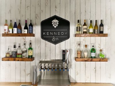 Kennedy Bar Black Metal Custom Business Sign on White Shiplap with Floating Shelves